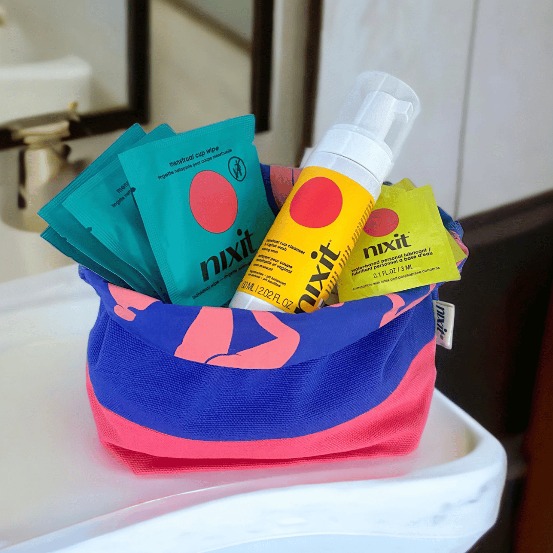 Colorful pouch on bathroom counter containing nixit menstrual disc wipes and personal lubricant bottle.