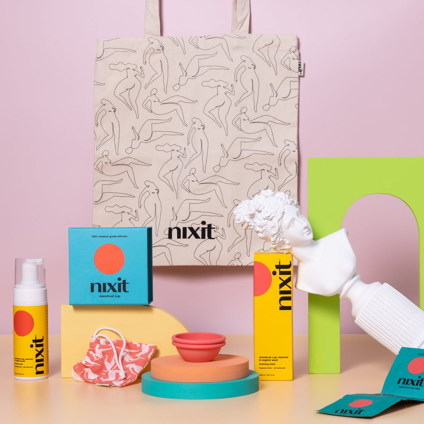 An image of an array of nixit products in the foreground (wash, menstrual cup and wipes) with the nixit tote hanging in the background