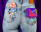 Photo of nixit carrying bag in our signature pattern, fitting perfectly into a jean back pocket for period care on the go